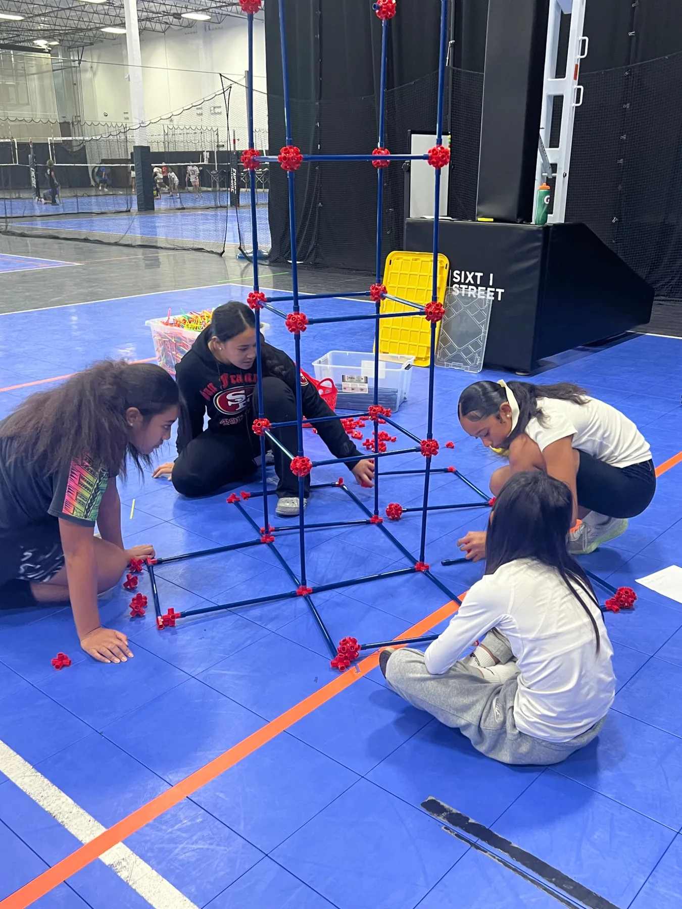 Students collaborating on a large team-building structure